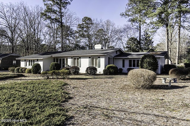 single story home featuring a chimney