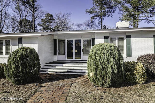 exterior space featuring brick siding and a chimney