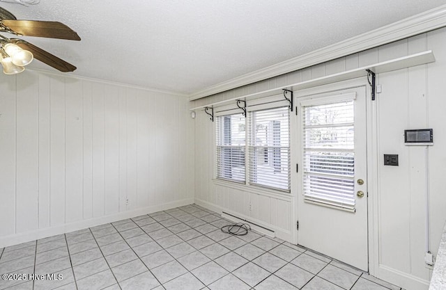 unfurnished room featuring a ceiling fan, a baseboard radiator, and crown molding