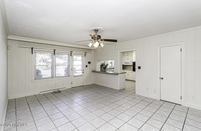 spare room with baseboards, ceiling fan, ornamental molding, a textured ceiling, and a baseboard heating unit