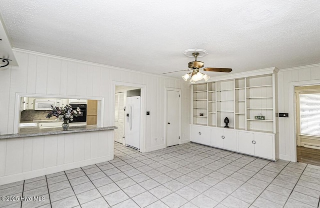 interior space with a textured ceiling, ornamental molding, and a ceiling fan