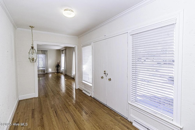 foyer entrance featuring ornamental molding, baseboard heating, dark wood-style flooring, and baseboards