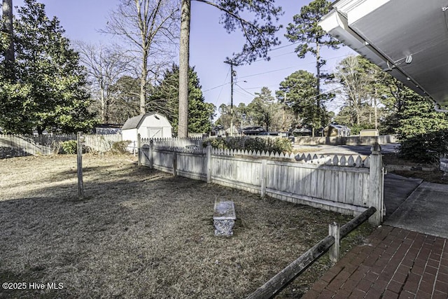 view of yard with an outbuilding, a storage unit, and a fenced backyard