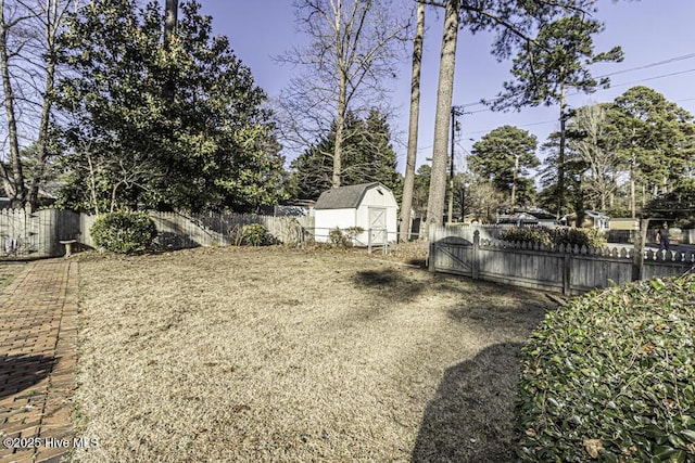 view of yard featuring a fenced backyard, an outdoor structure, and a shed