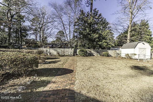 view of yard with a storage unit, fence, and an outdoor structure