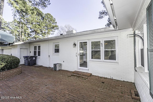 rear view of property with a patio area and brick siding