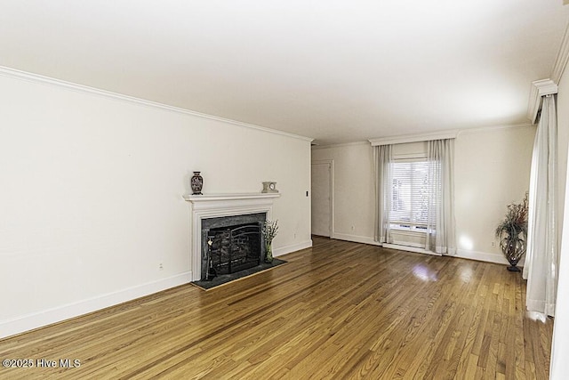 unfurnished living room featuring crown molding, a fireplace, baseboards, and wood finished floors