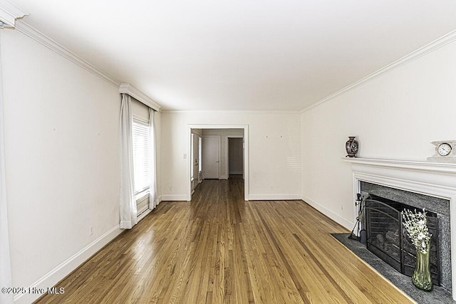 unfurnished living room with a fireplace with flush hearth, crown molding, baseboards, and wood finished floors