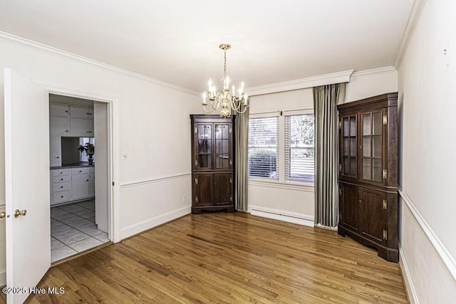 interior space featuring a chandelier, ornamental molding, a baseboard radiator, and wood finished floors