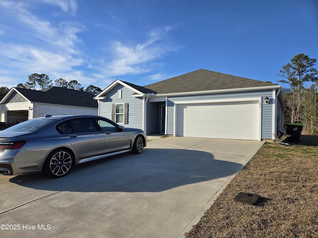 single story home with an attached garage, concrete driveway, and roof with shingles