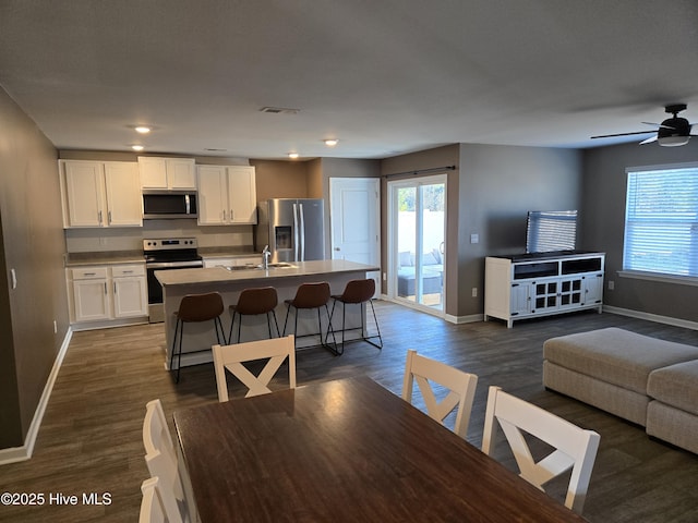 interior space featuring a wealth of natural light, dark wood-style flooring, and baseboards