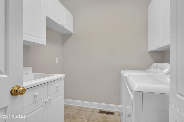 washroom with washer and clothes dryer, cabinet space, light tile patterned flooring, a sink, and baseboards