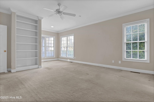 spare room featuring baseboards, visible vents, ornamental molding, and carpet flooring