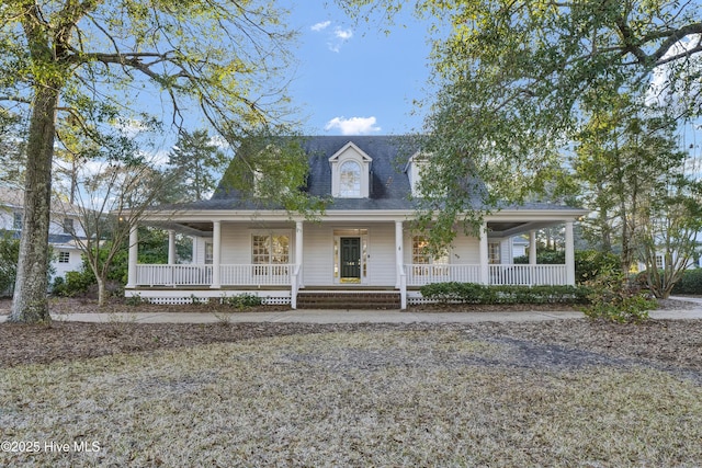 farmhouse-style home featuring a porch and roof with shingles