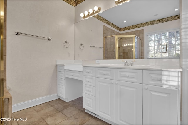 full bath with baseboards, a stall shower, vanity, and tile patterned floors