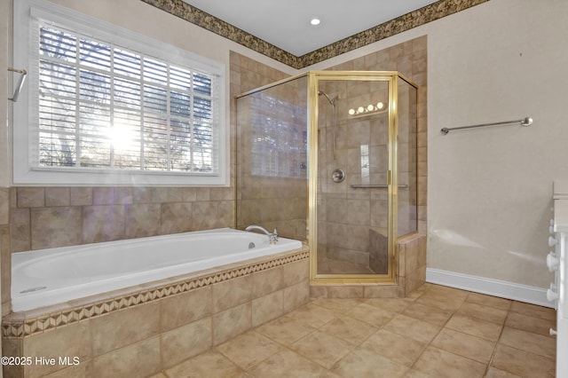 full bath featuring a stall shower, baseboards, a bath, and tile patterned floors