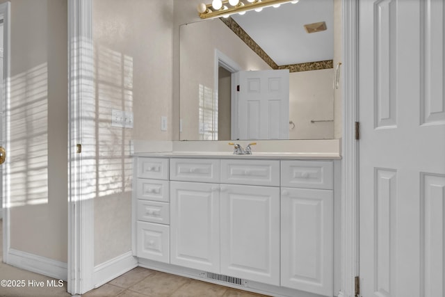 bathroom with tile patterned flooring, vanity, visible vents, and baseboards