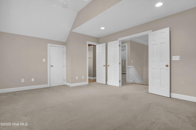 unfurnished bedroom featuring baseboards, vaulted ceiling, recessed lighting, and light colored carpet