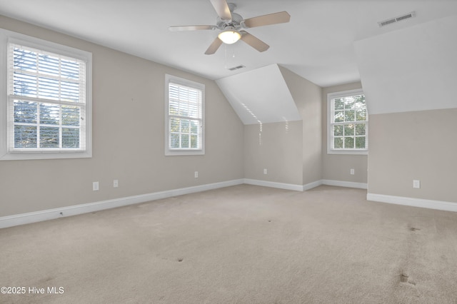 bonus room with a wealth of natural light, visible vents, and light colored carpet