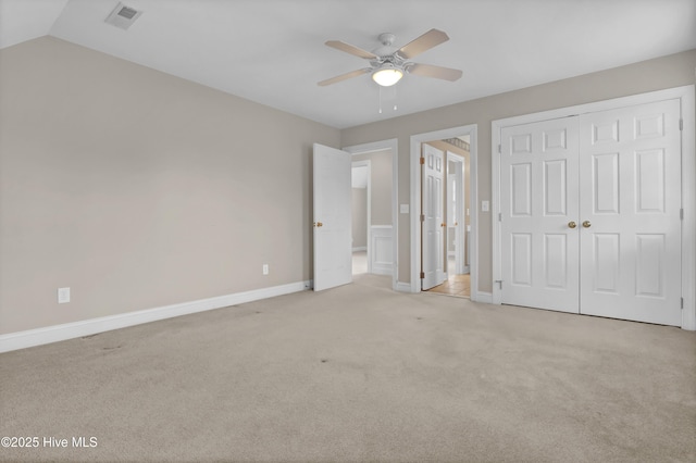 unfurnished bedroom with a closet, visible vents, light carpet, and baseboards