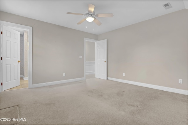 unfurnished bedroom with light carpet, ensuite bath, visible vents, and baseboards