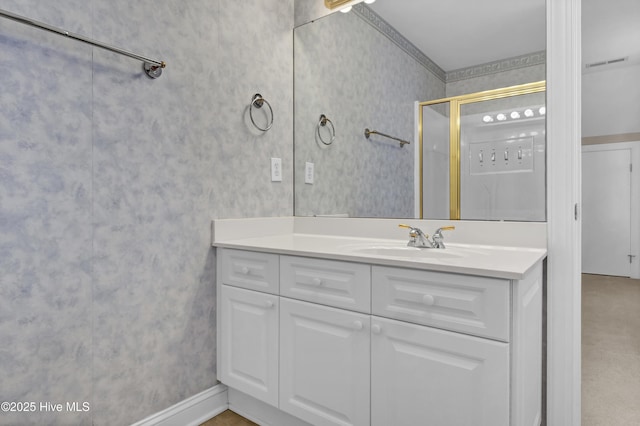 full bathroom featuring visible vents, a shower with door, vanity, and wallpapered walls