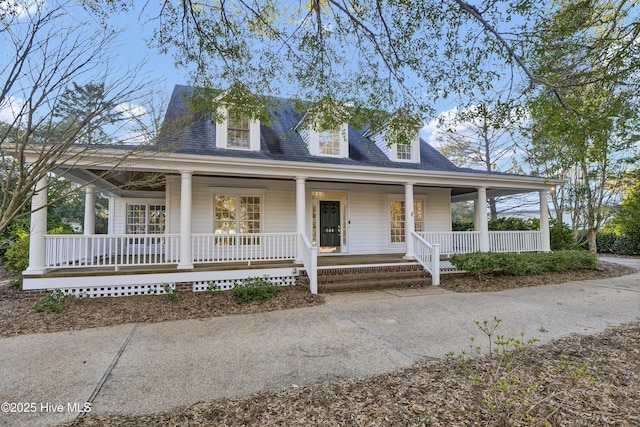 farmhouse featuring covered porch and roof with shingles