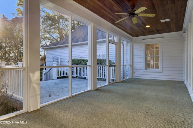 unfurnished sunroom featuring wood ceiling and ceiling fan