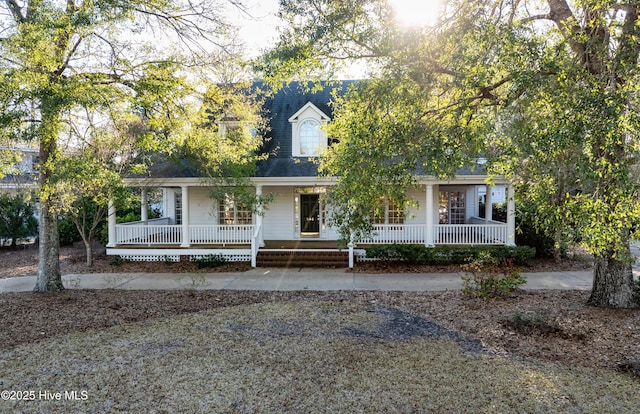 view of front of home featuring covered porch and a shingled roof