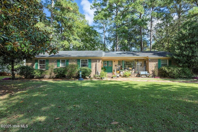 ranch-style home with a front yard, covered porch, and brick siding