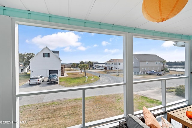 interior space with a residential view, a healthy amount of sunlight, and a water view