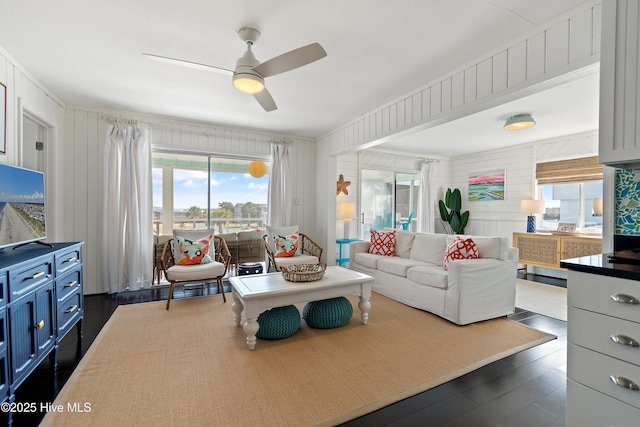 living room featuring dark wood-style floors and a ceiling fan