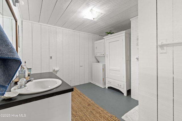 bathroom featuring stacked washer and dryer, concrete floors, and vanity