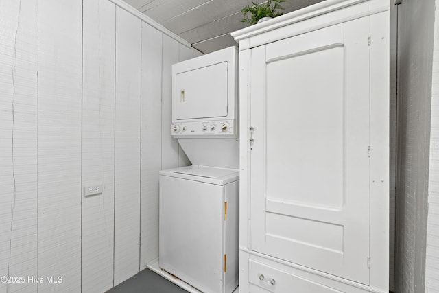 clothes washing area with stacked washer and clothes dryer