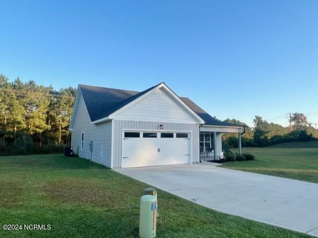 view of front facade with concrete driveway, board and batten siding, an attached garage, and a front yard