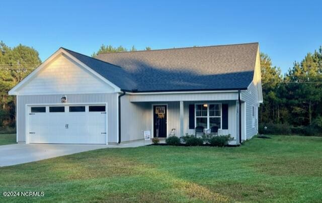 ranch-style house featuring concrete driveway, an attached garage, covered porch, board and batten siding, and a front yard