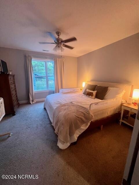 bedroom featuring baseboards, dark carpet, and a ceiling fan