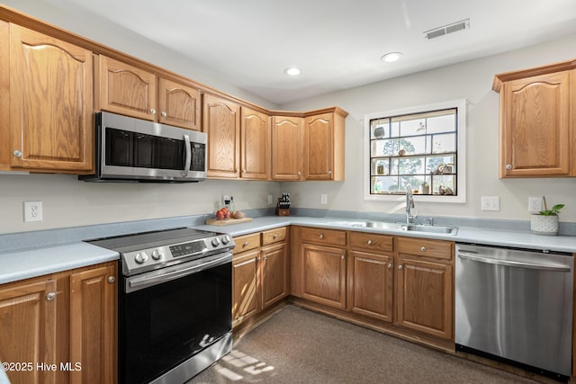 kitchen with stainless steel appliances, light countertops, a sink, and visible vents