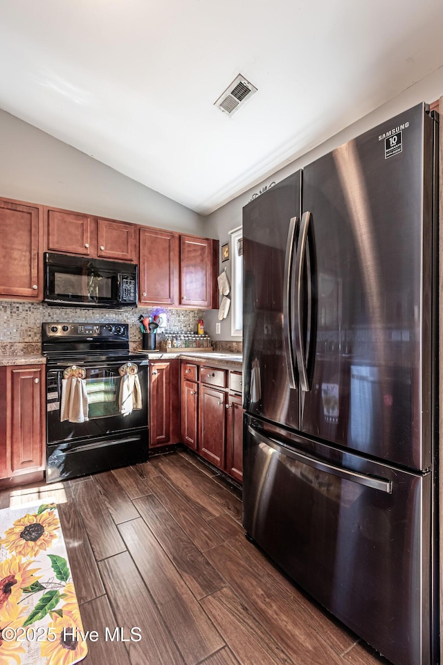 kitchen with visible vents, black appliances, tasteful backsplash, dark wood finished floors, and vaulted ceiling