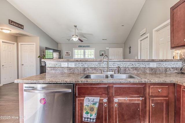 kitchen with a sink, stainless steel dishwasher, a ceiling fan, and vaulted ceiling