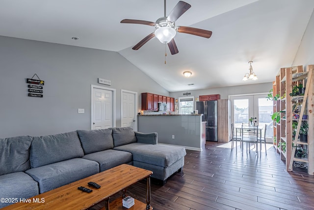 living room with dark wood finished floors, ceiling fan with notable chandelier, french doors, and vaulted ceiling