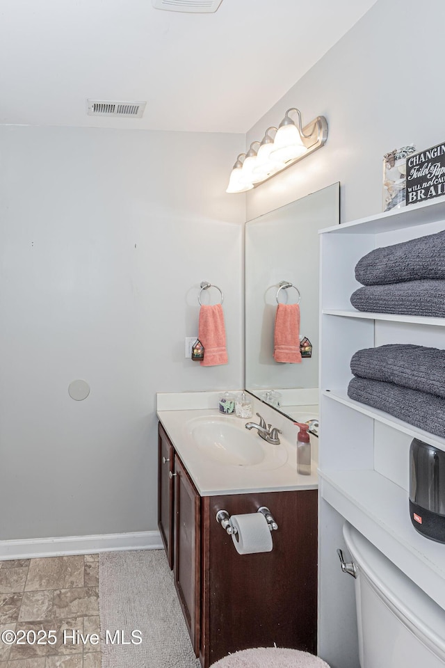 bathroom with visible vents, baseboards, and vanity