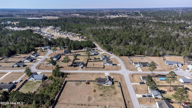 birds eye view of property featuring a forest view