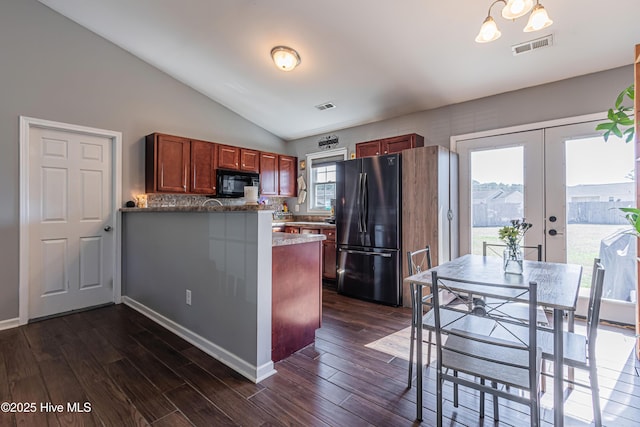 kitchen featuring dark wood finished floors, visible vents, freestanding refrigerator, and black microwave