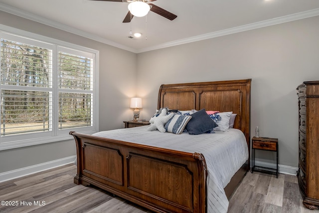 bedroom with ornamental molding, light wood-style floors, a ceiling fan, and baseboards