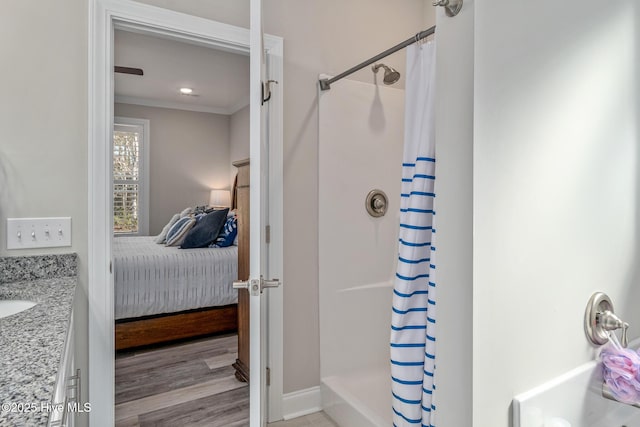 full bath featuring ensuite bath, wood finished floors, crown molding, and a shower stall