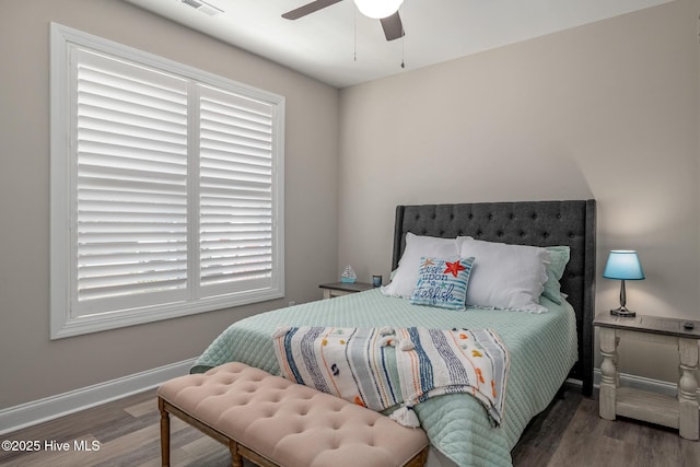 bedroom featuring dark wood-style flooring, visible vents, ceiling fan, and baseboards