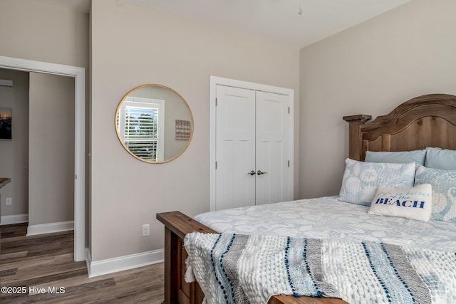 bedroom featuring dark wood-style floors, a closet, and baseboards