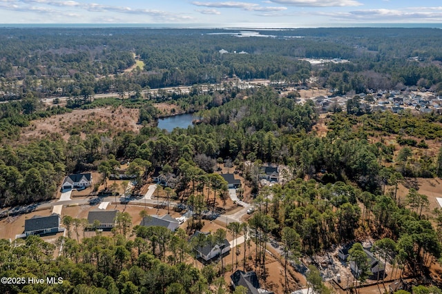 drone / aerial view with a water view and a wooded view