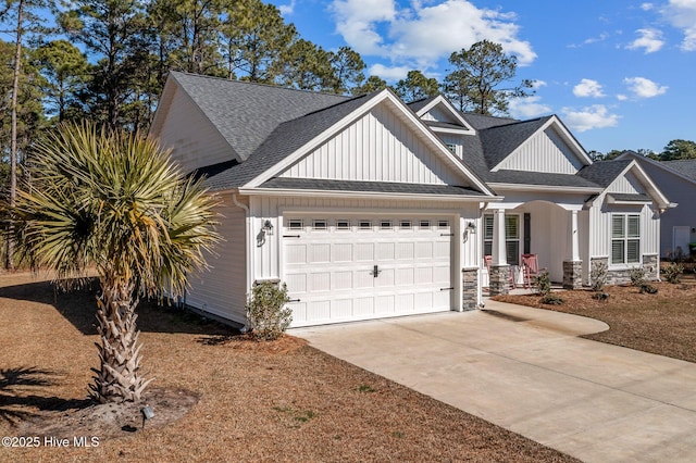 view of front of home with a garage, driveway, board and batten siding, and roof with shingles